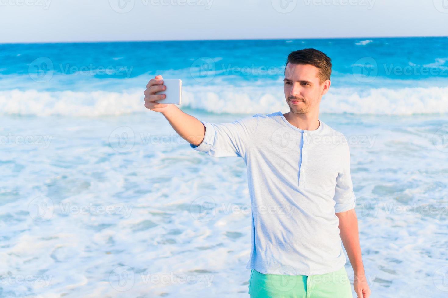 giovane uomo assunzione autoscatto su il spiaggia su caraibico vacanza foto