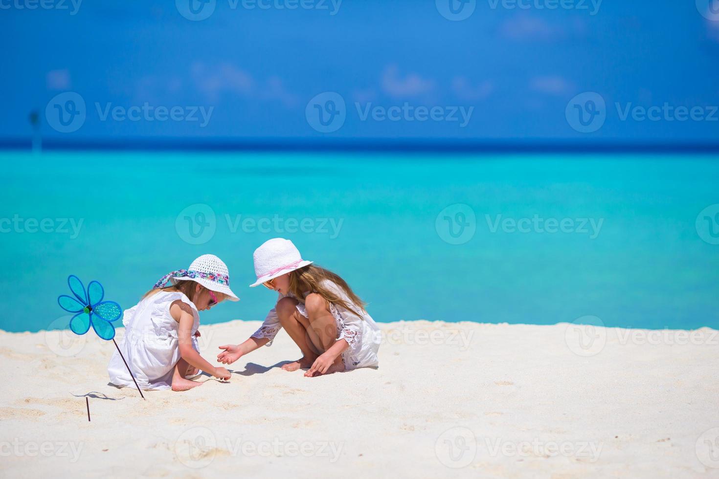 poco adorabile ragazze disegno immagine su bianca spiaggia foto