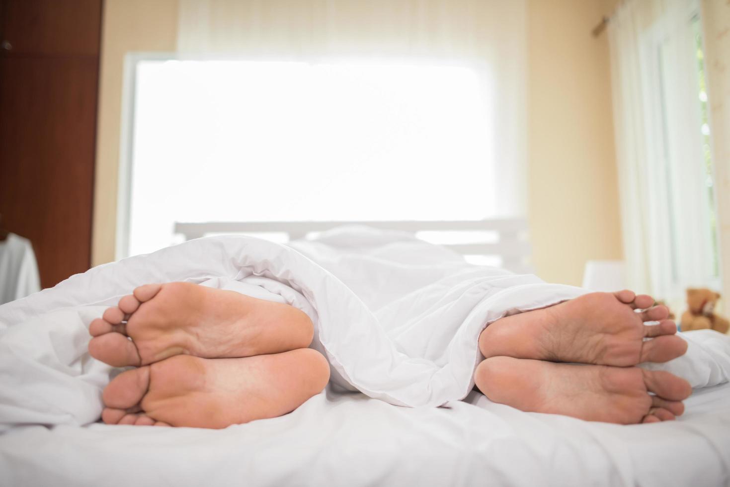 i piedi della coppia nel letto foto