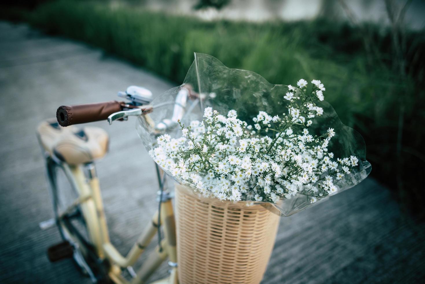 bicicletta vintage con cesto pieno di fiori selvatici foto