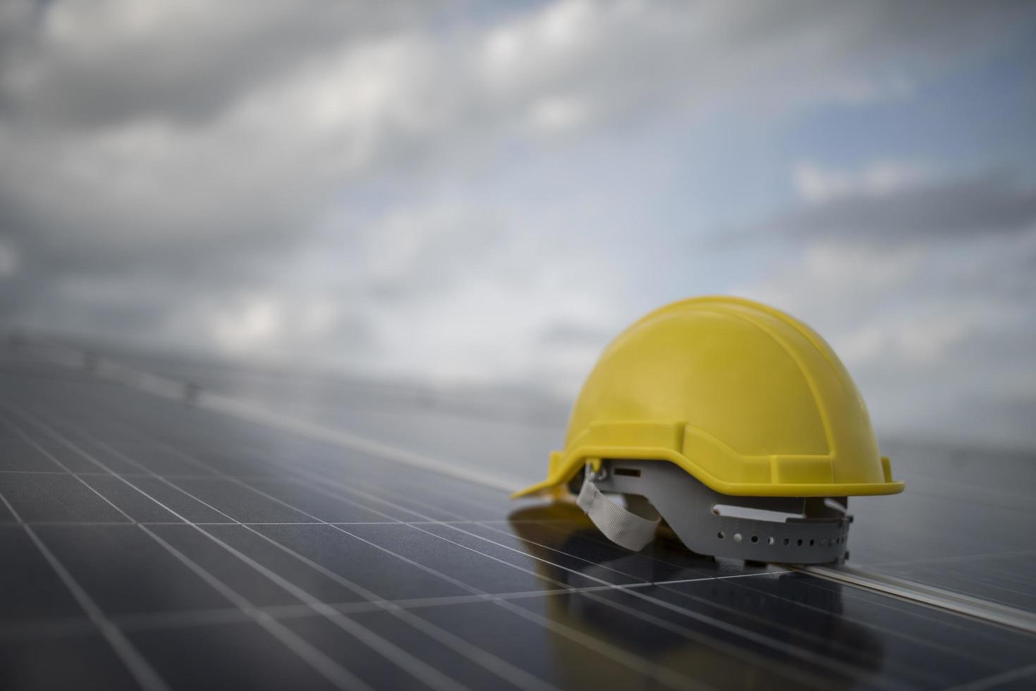 casco di sicurezza giallo sul pannello solare foto