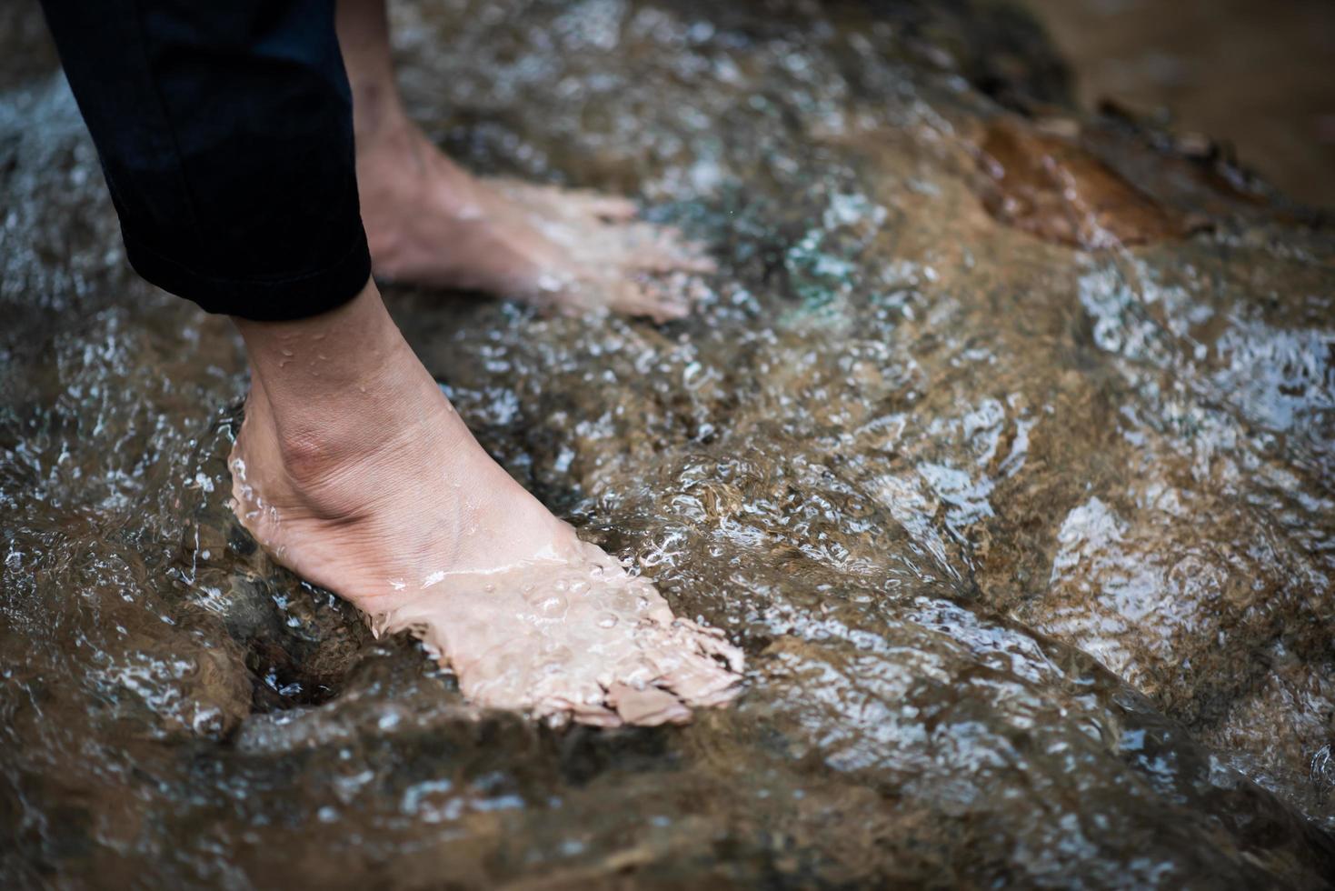 i piedi vengono raffreddati dall'acqua del fiume foto