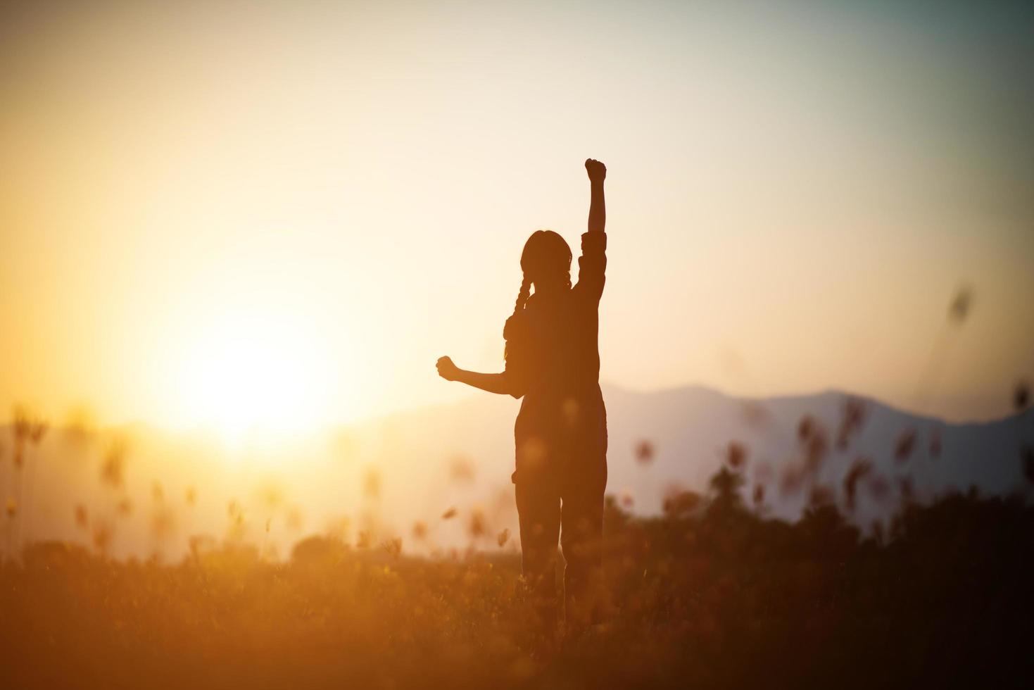 silhouette di una donna che prega su uno sfondo di bel cielo foto