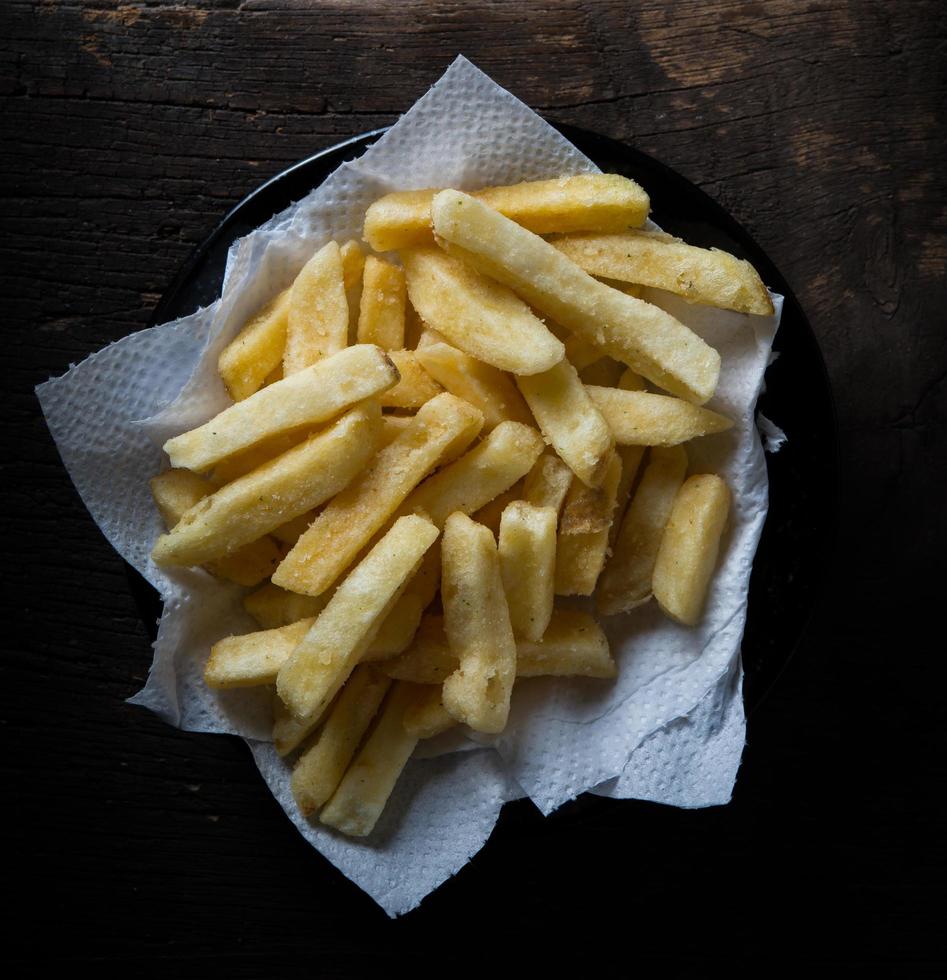 gustose patatine fritte sul fondo della tavola in legno foto