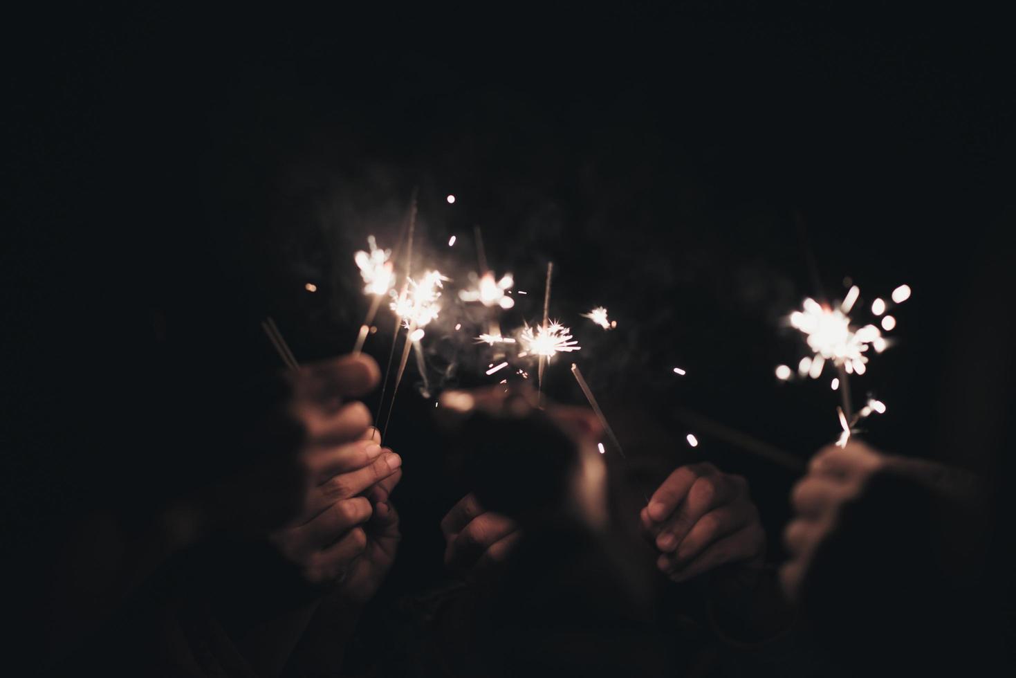 gruppo di persone che tengono le stelle filanti durante la notte foto