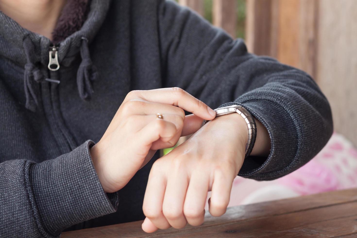 persona che controlla l'ora su un orologio da polso foto