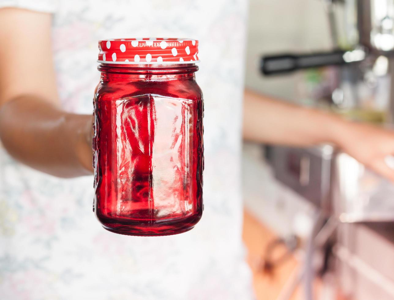 barista che tiene un barattolo rosso foto