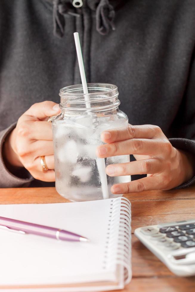 mani che tengono un bicchiere d'acqua fredda foto