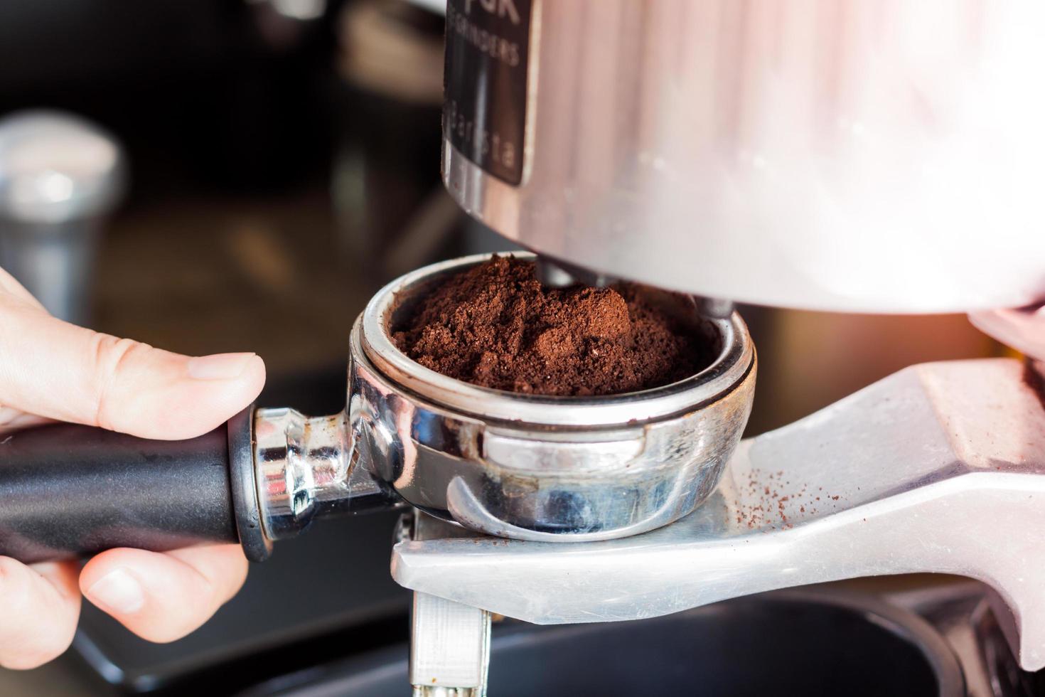 primo piano di una mano che tiene un macinino da caffè foto