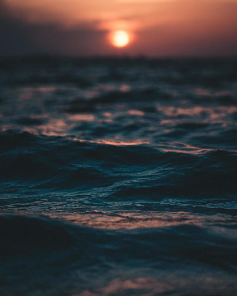 primo piano delle onde al tramonto foto