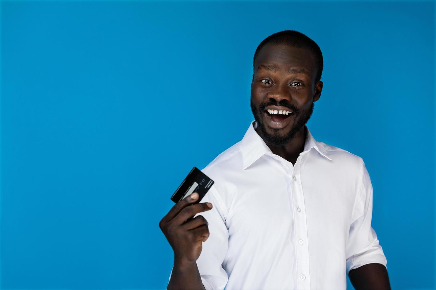 uomo sorridente con una carta di credito foto