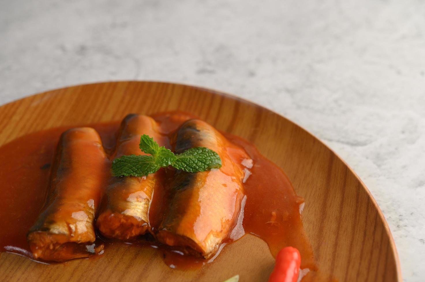 sarde in salsa di pomodoro su un vassoio di legno foto