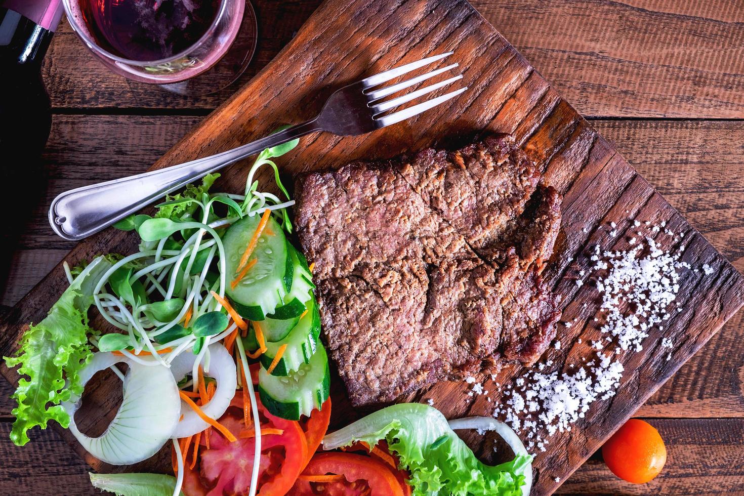 primo piano di bistecca e su un tagliere di legno foto