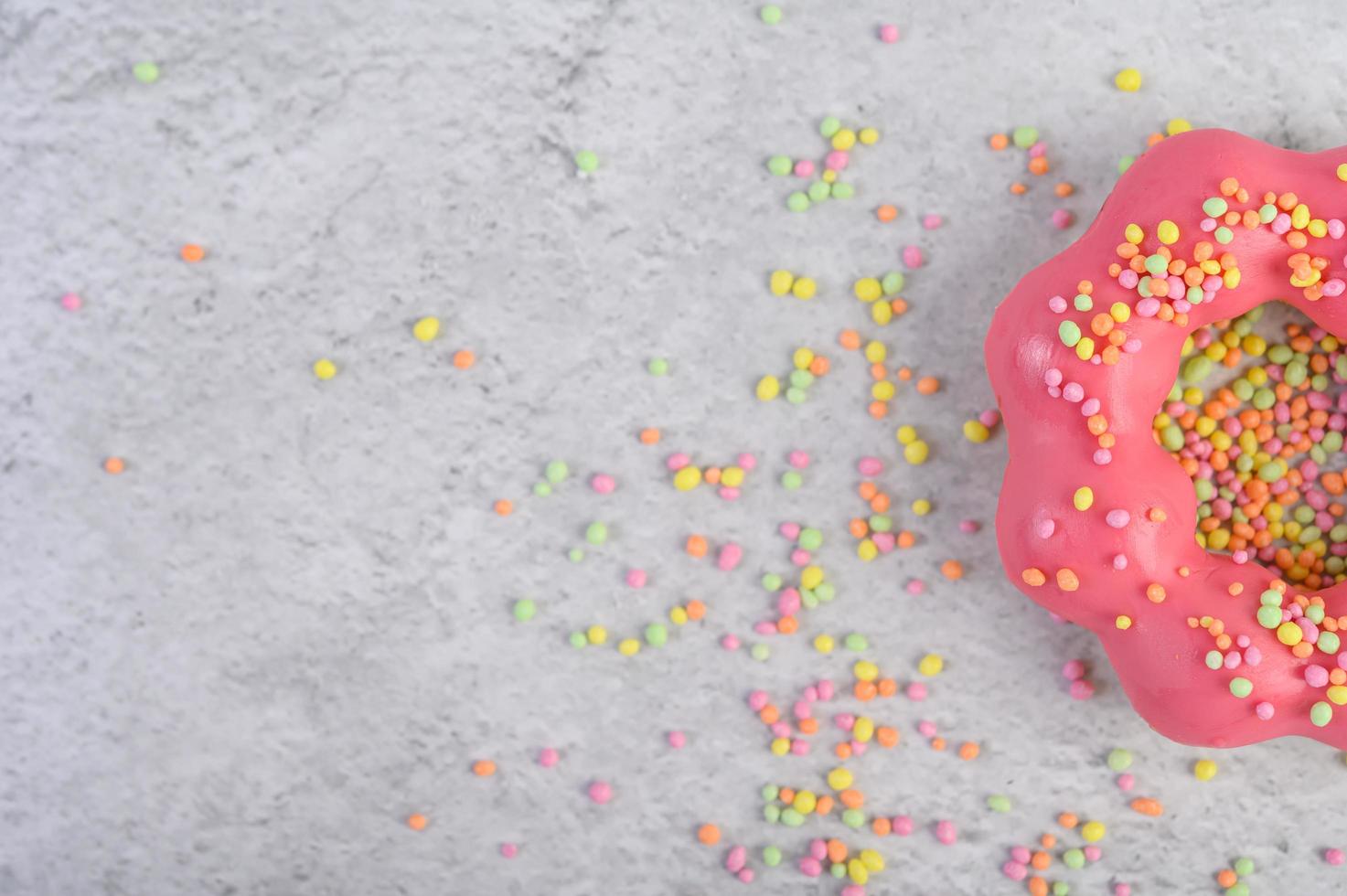 mezza ciambella alle fragole decorata con glassa e codette foto