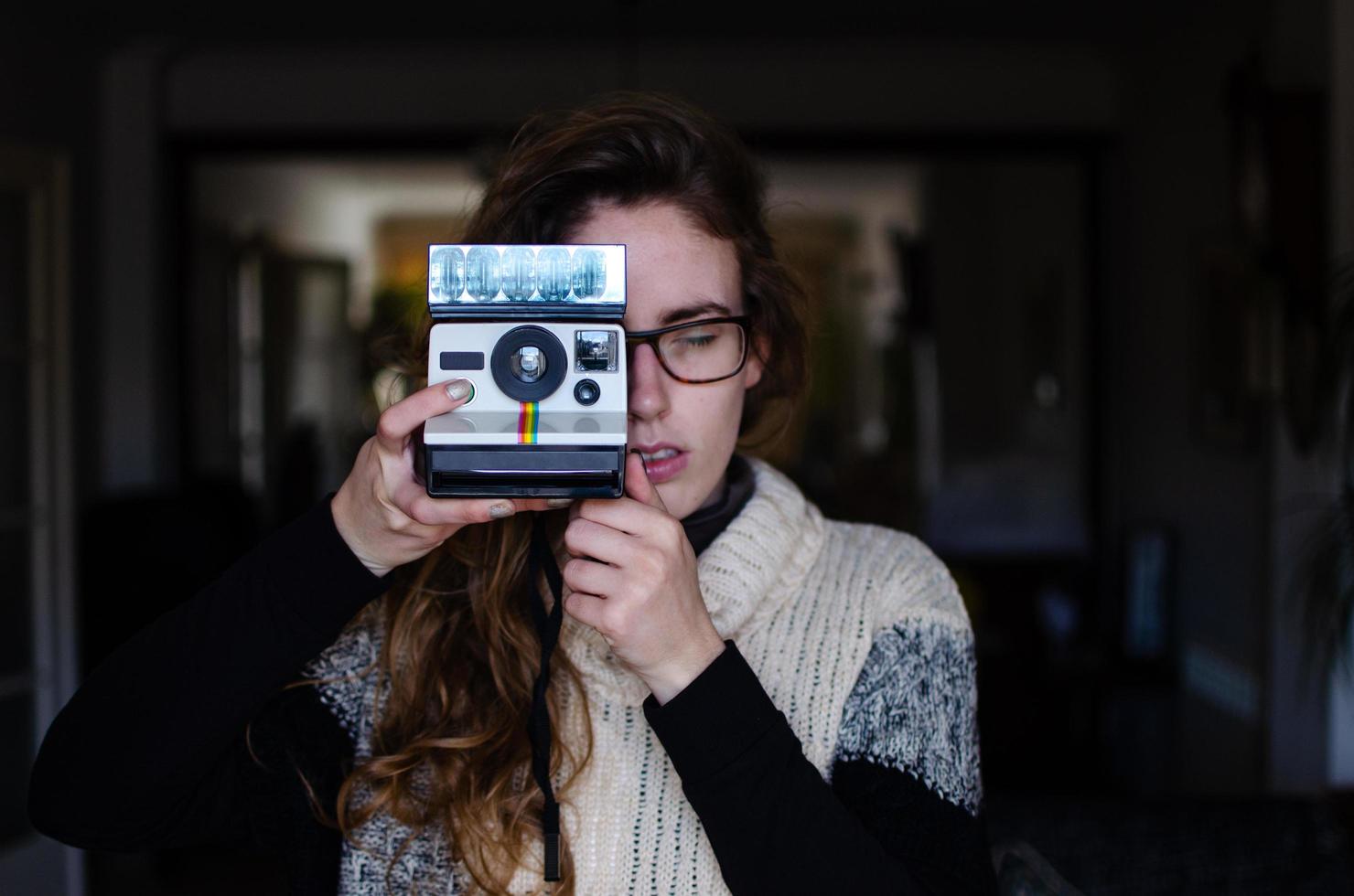 ragazza utilizzando una fotocamera polaroid foto