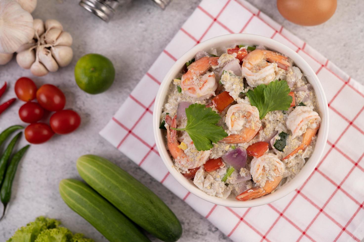 insalata di gamberi con cipolla rossa di pomodoro e coriandolo in una tazza bianca foto