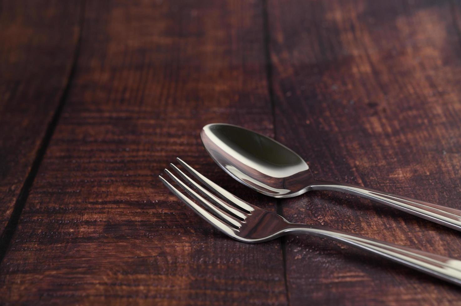 forchetta e cucchiaio in acciaio inox su un tavolo di legno foto