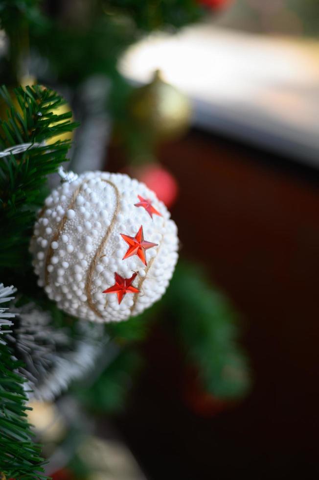 primo piano di una palla bianca appesa all'albero di Natale foto