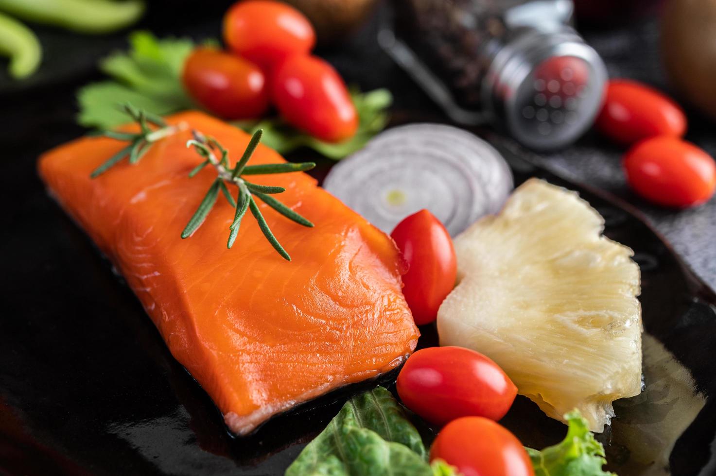 filetto di salmone crudo con pepe, kiwi, ananas e rosmarino foto