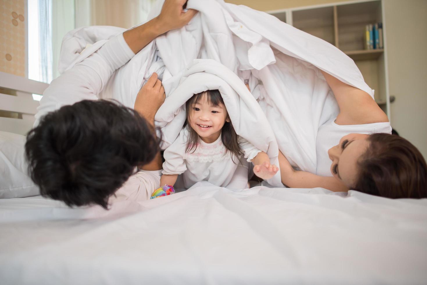 bambino felice con i genitori che giocano foto