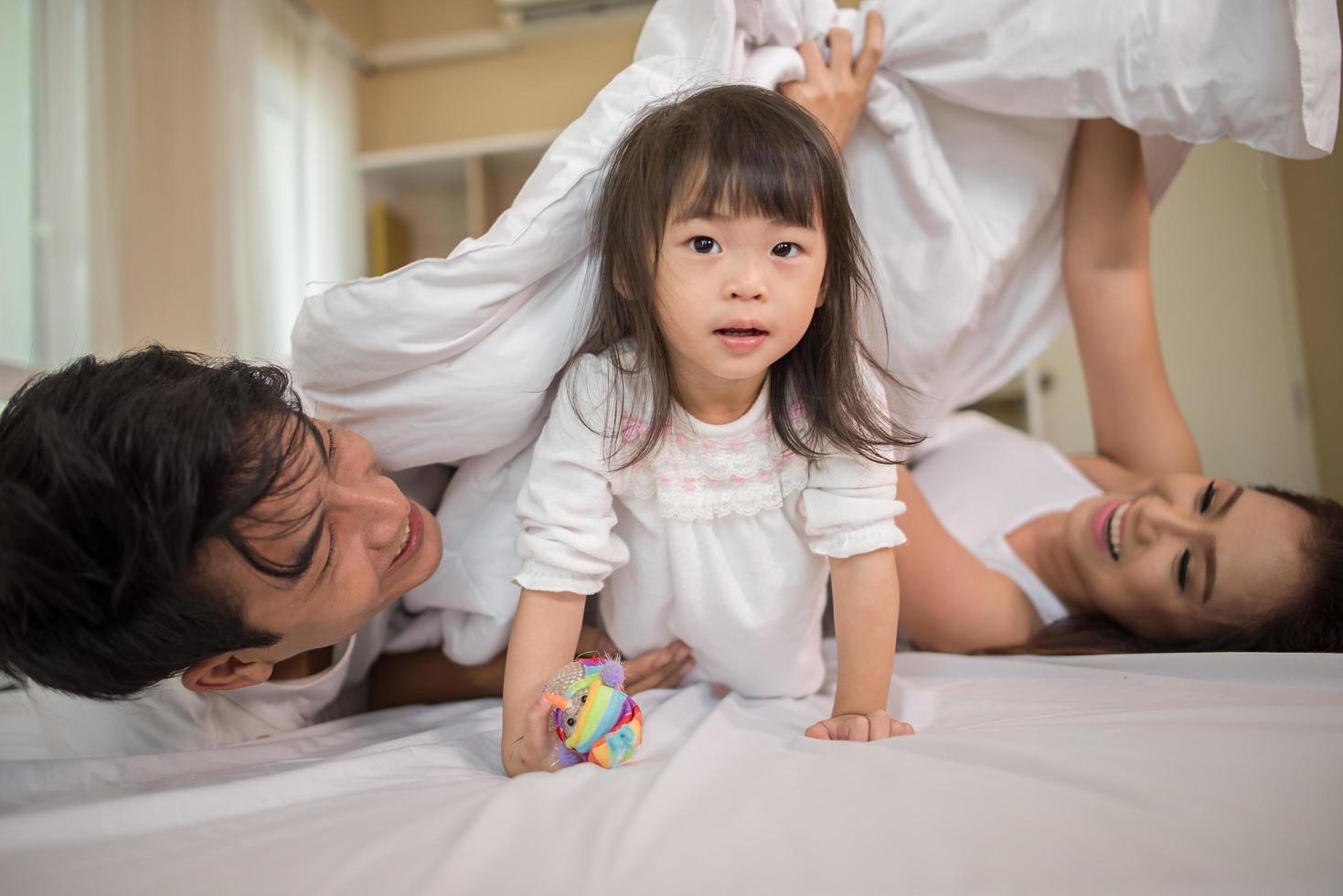 bambino felice con i genitori che giocano foto