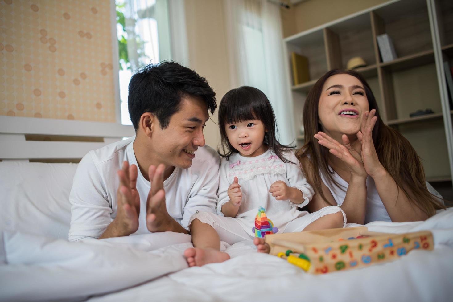 bambino felice con i genitori che giocano foto