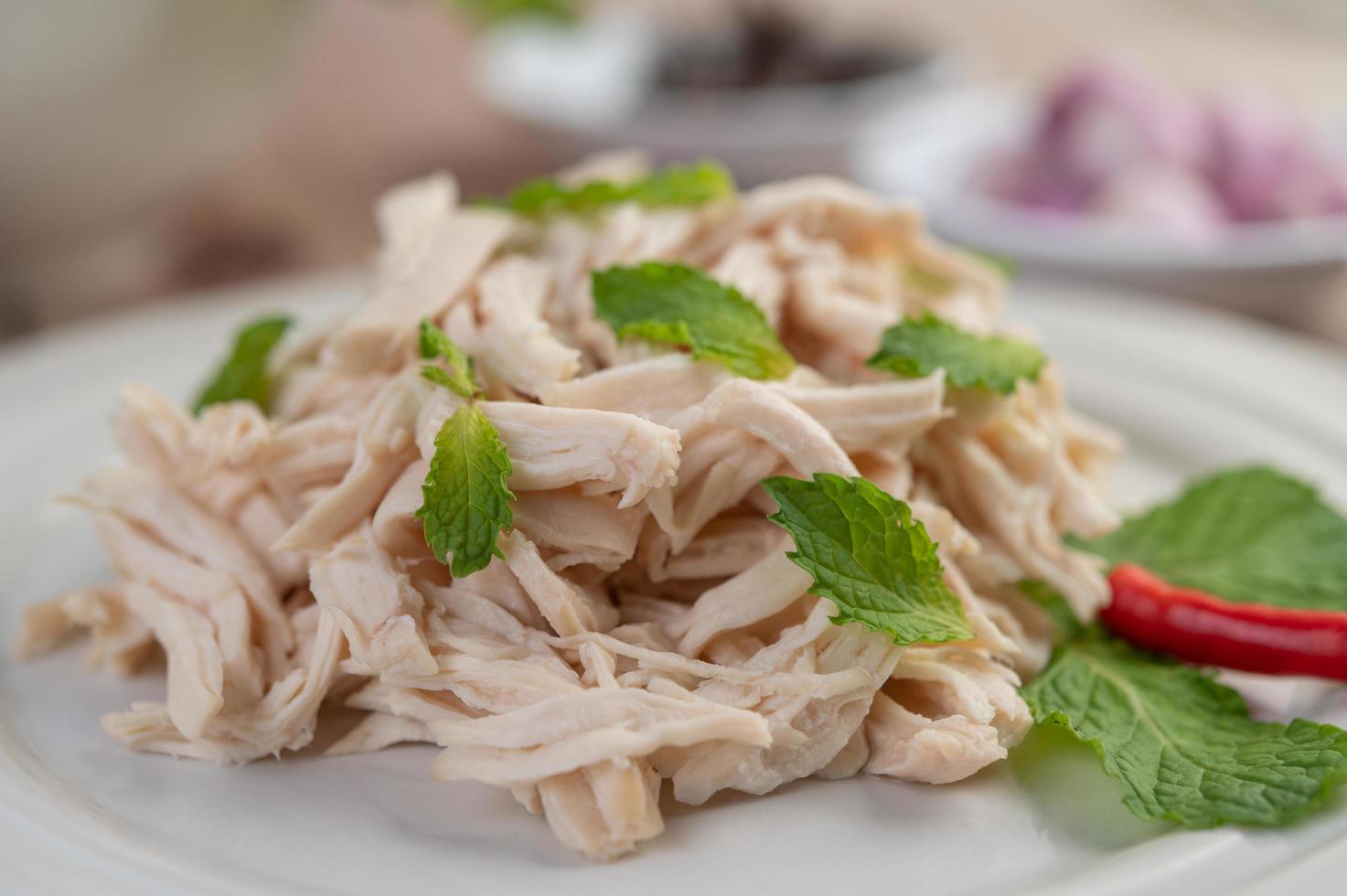 insalata di pollo su un piatto bianco con foglie di menta foto