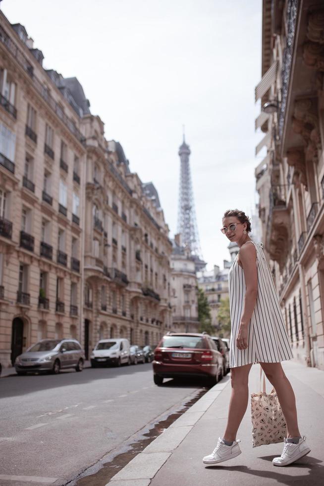 donna che cammina sul marciapiede a Parigi foto