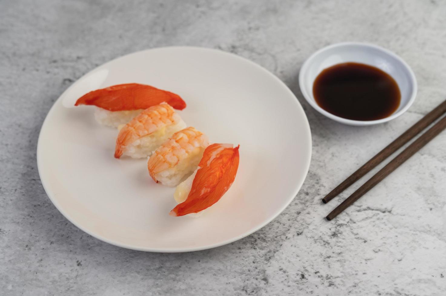 sushi placcato con salsa e bacchette foto