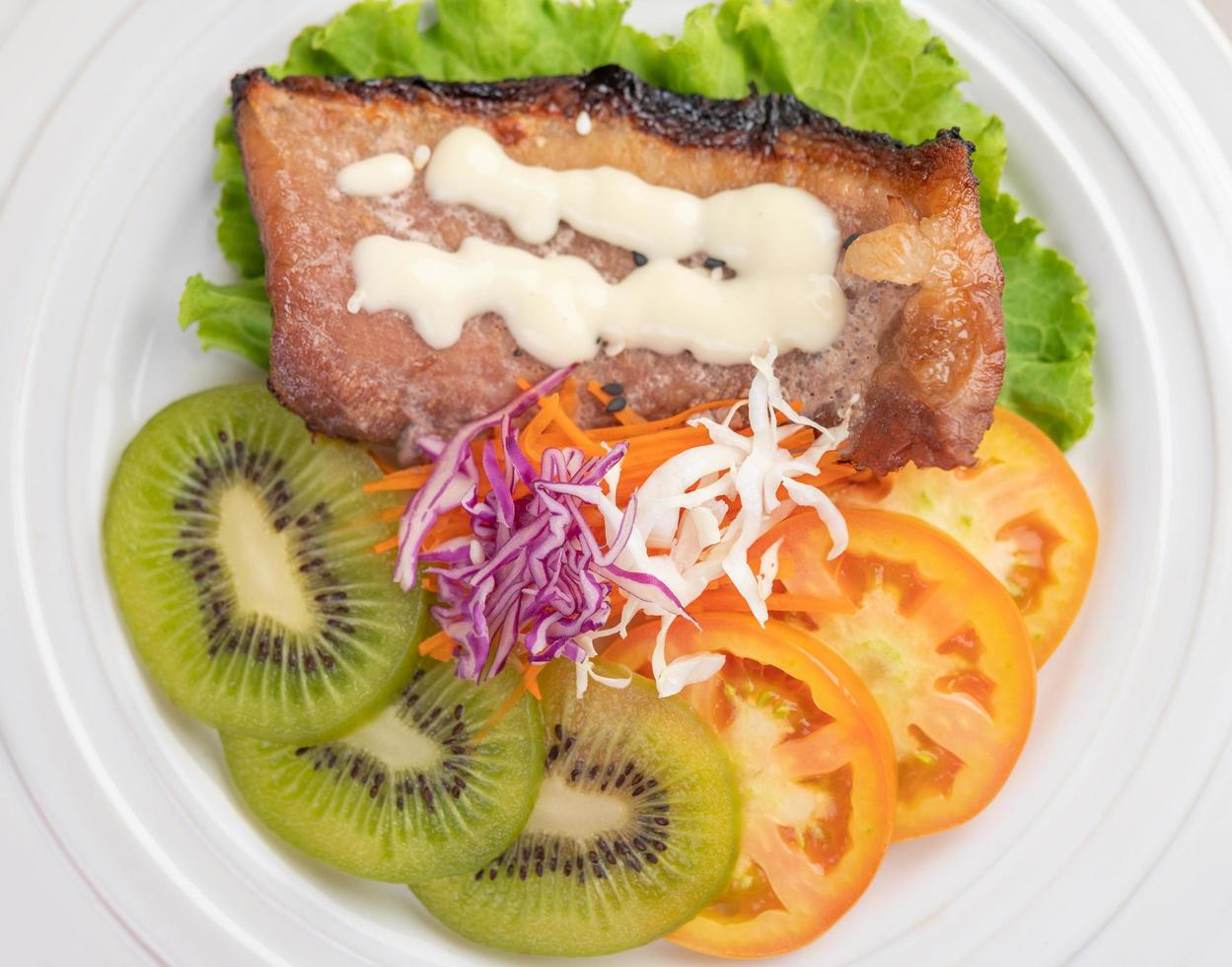 bistecca di pesce con patatine fritte, frutta e verdura foto