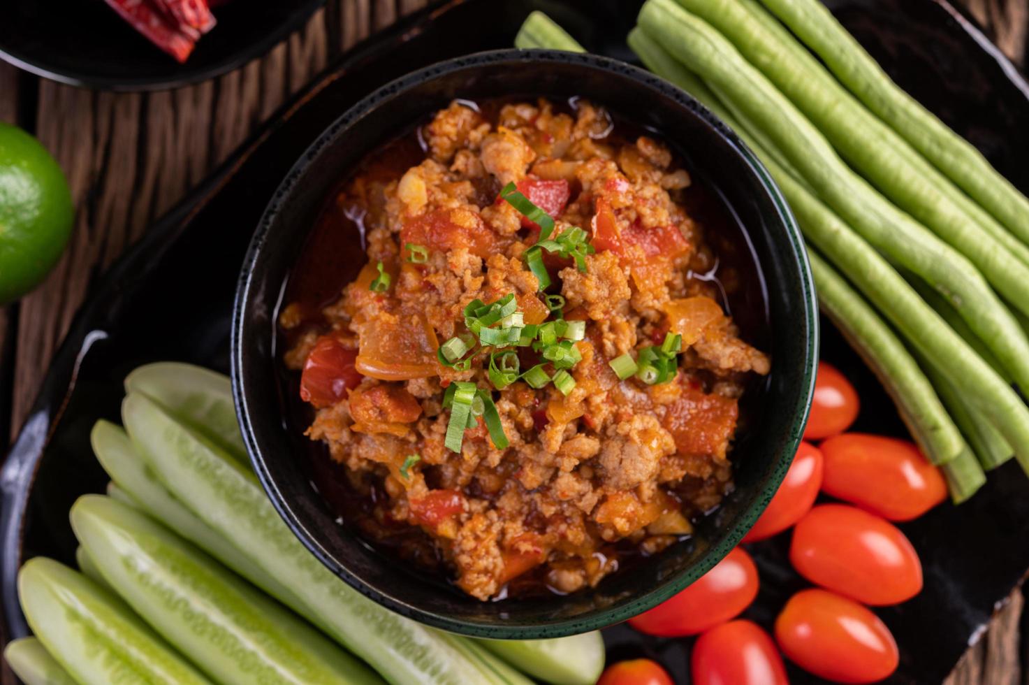 ciotola di maiale dolce con cetrioli, fagioli lunghi e pomodori foto