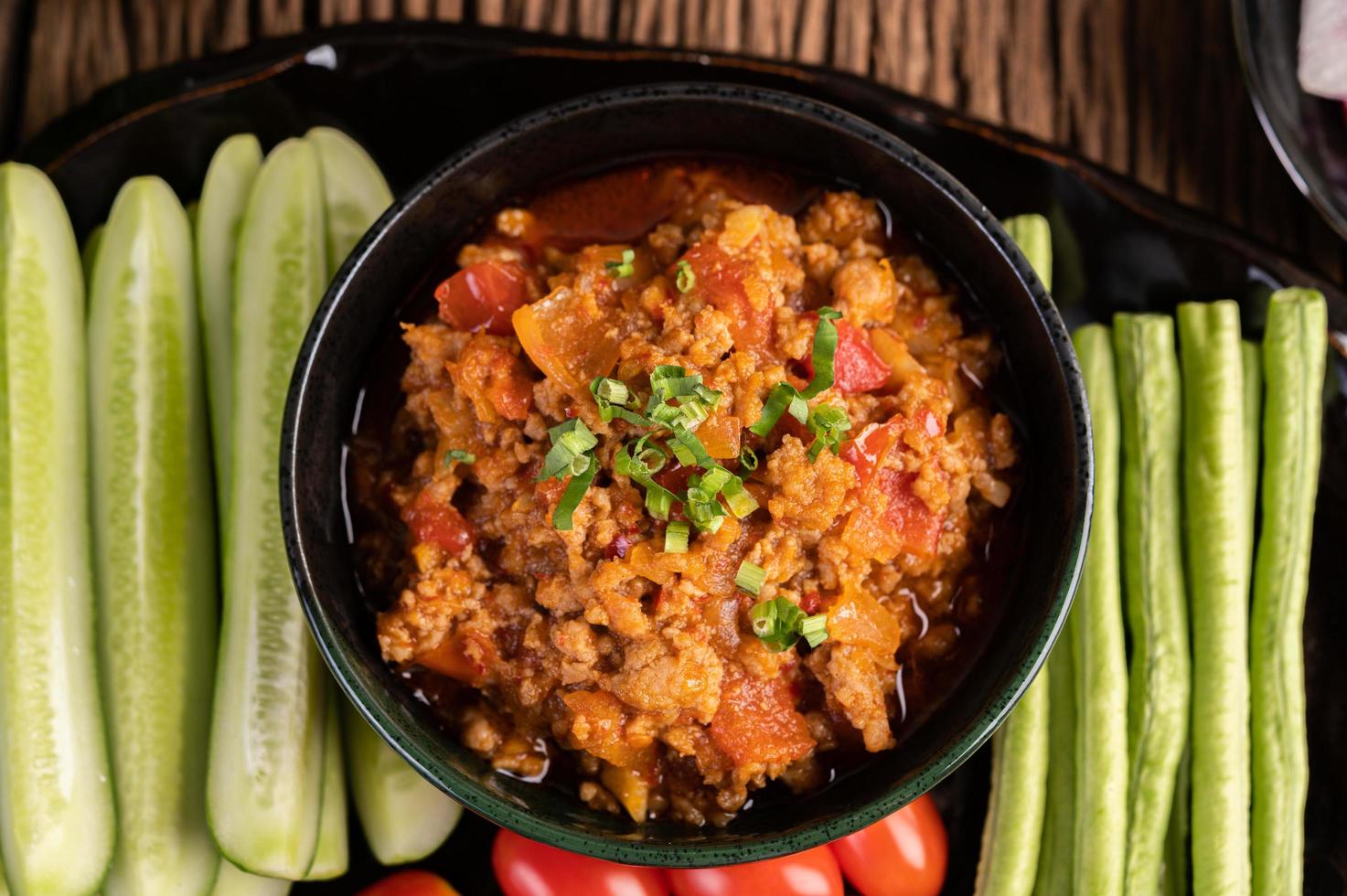 maiale con cetrioli, fagioli lunghi, pomodori e contorni foto