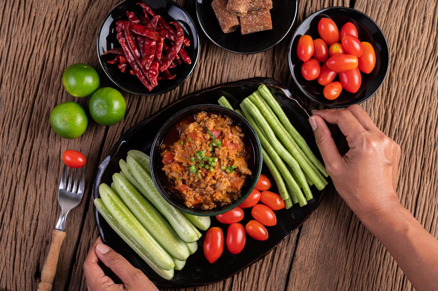 ciotola di maiale dolce con cetrioli, fagioli lunghi e pomodori foto