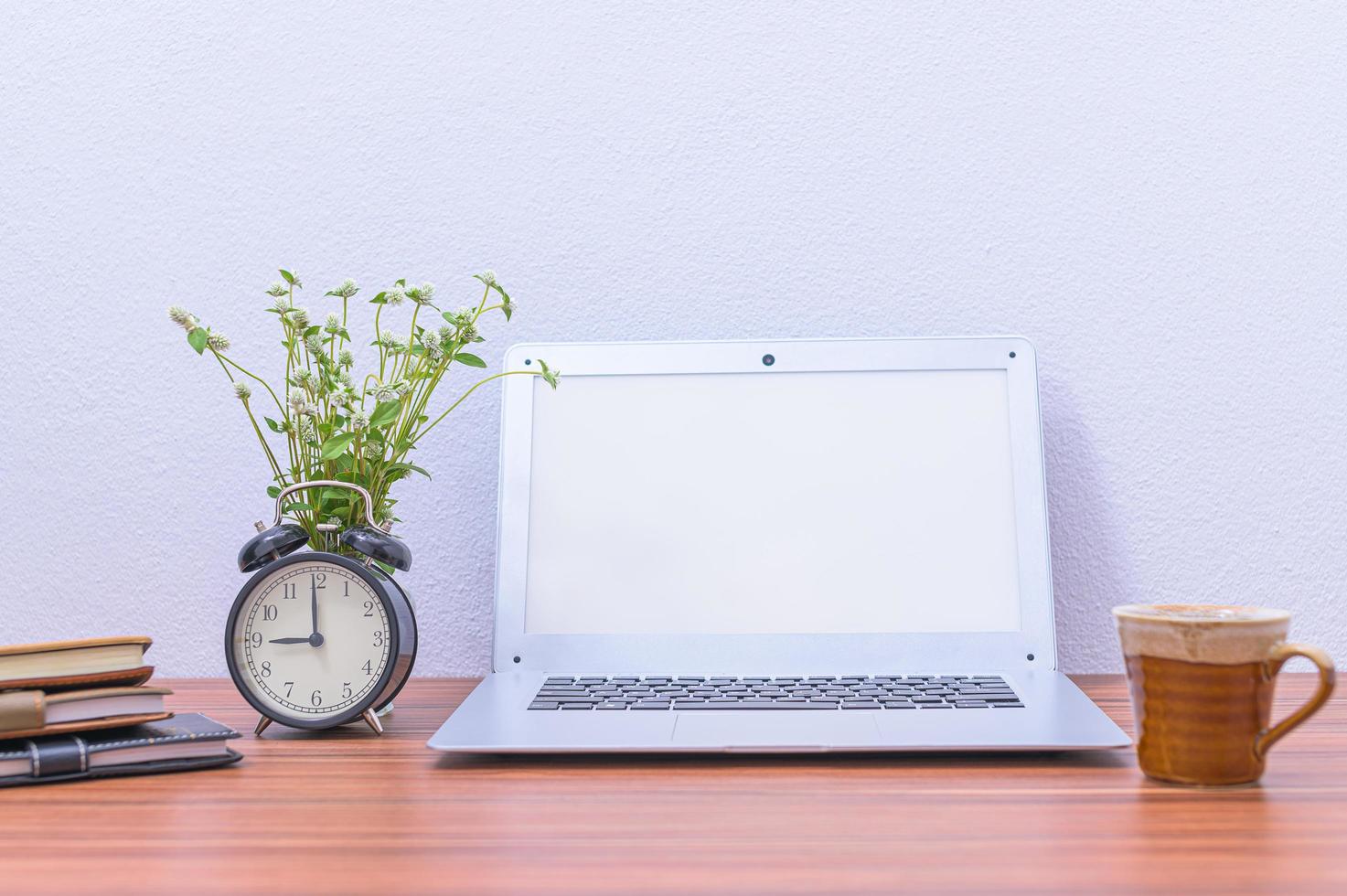 laptop e fiore sulla scrivania foto