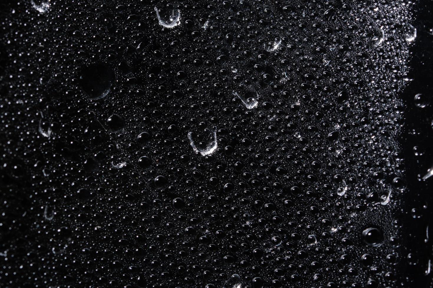 goccioline sul foglio di plastica trasparente, sfondo nero foto