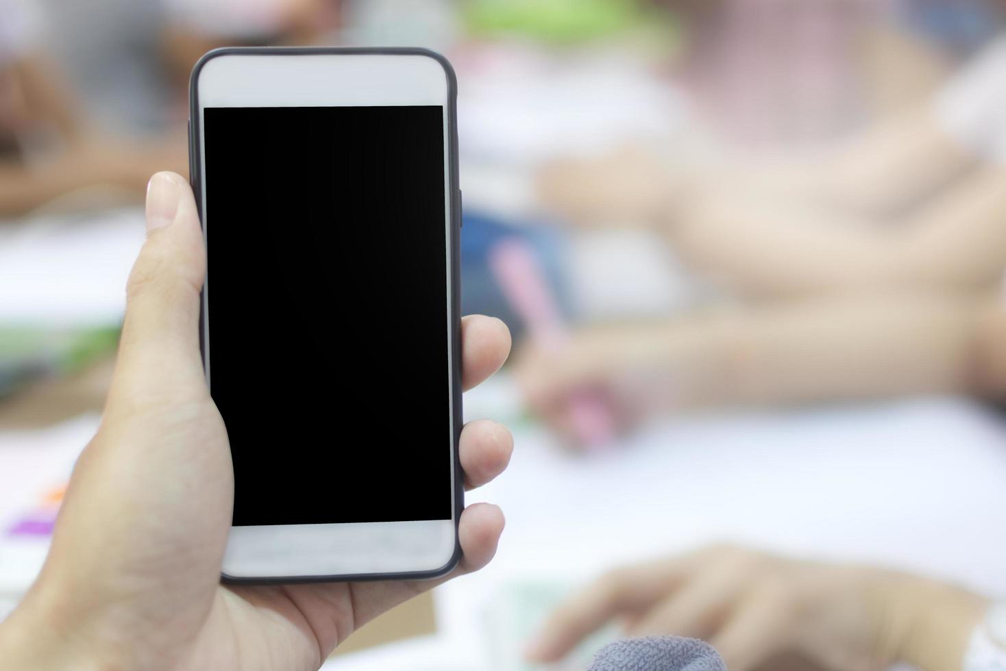 primo piano di una persona in possesso di un modello di telefono foto