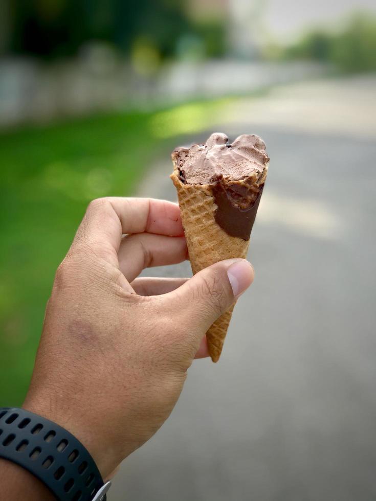 mano che tiene il gelato con sfocatura dello sfondo della natura. stagione estiva. foto