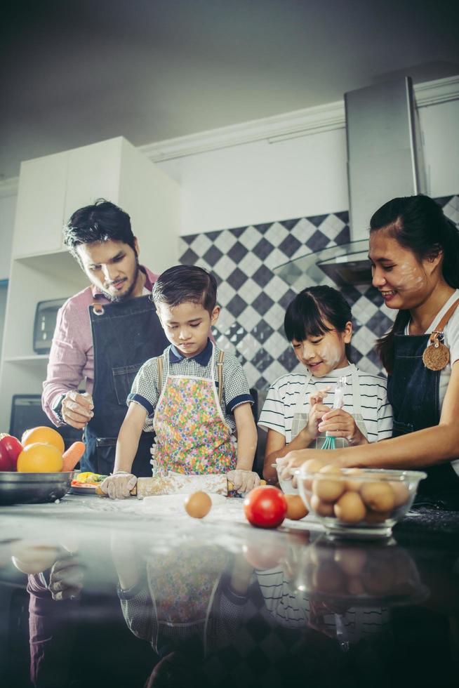 famiglia felice che gode del loro tempo cucinando insieme in cucina foto