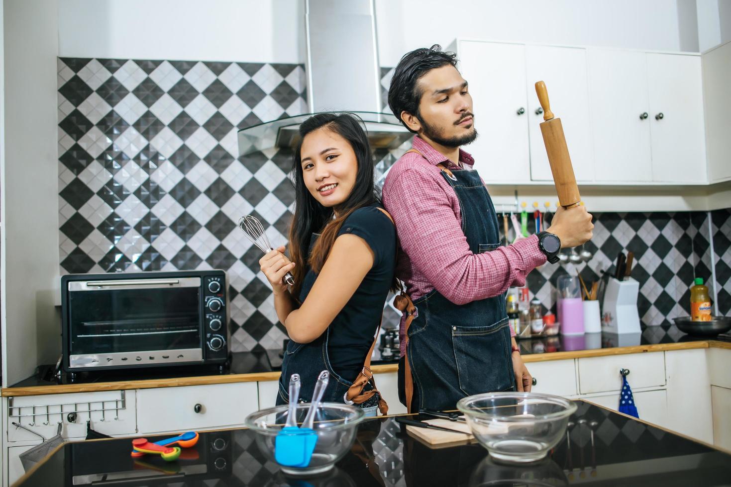 coppia attraente che cucina nella loro cucina a casa foto