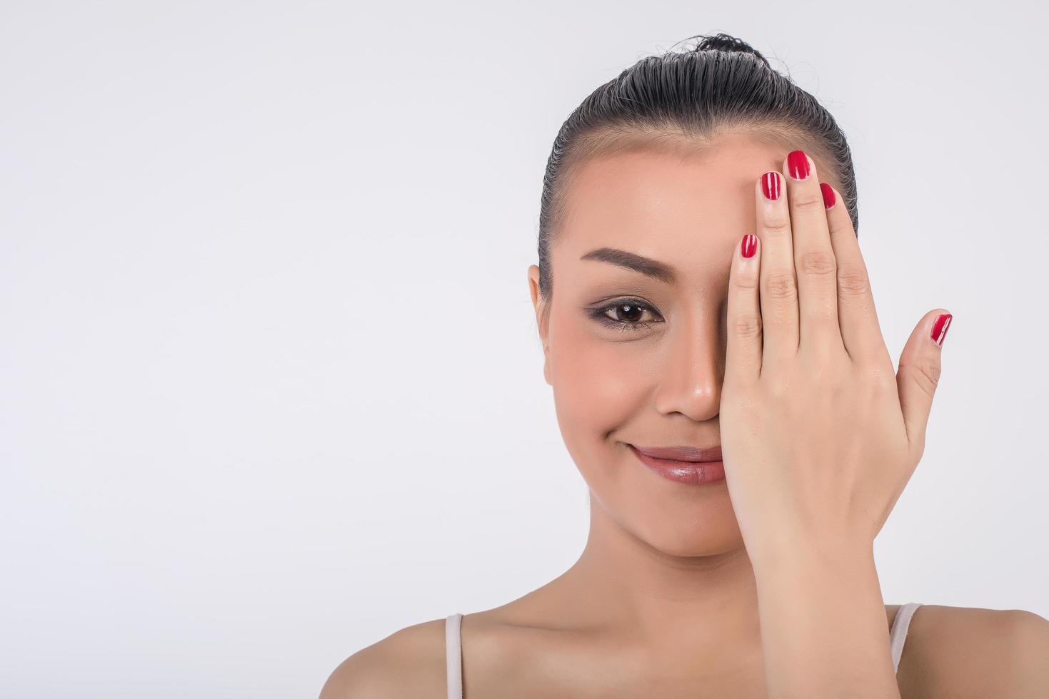 bella giovane donna si copre il viso con le mani foto