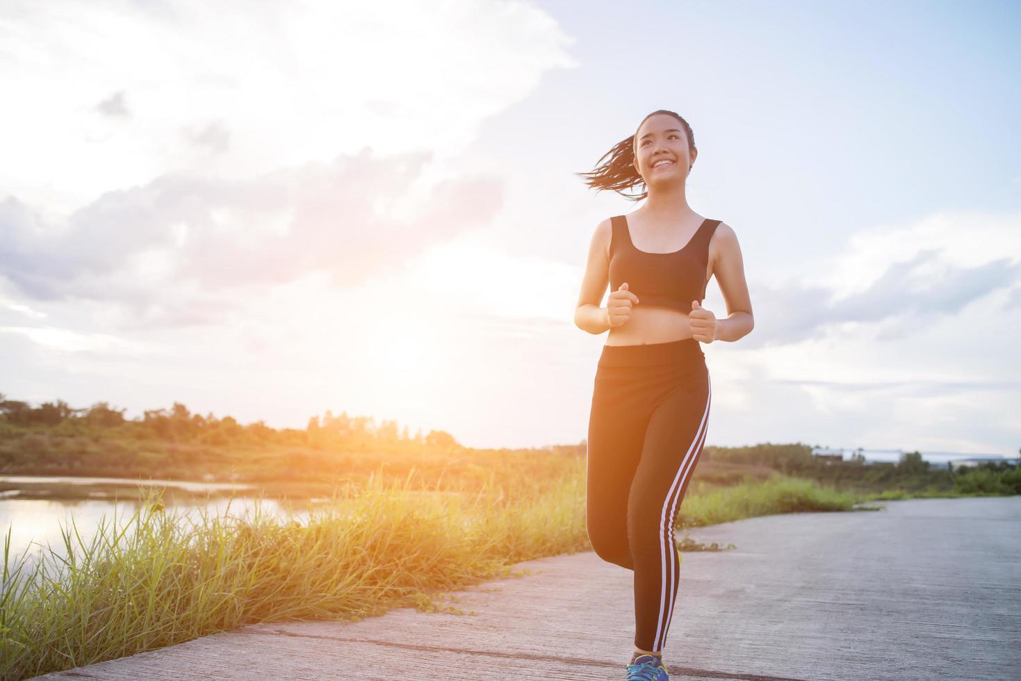 un giovane corridore femminile felice fare jogging all'aperto foto