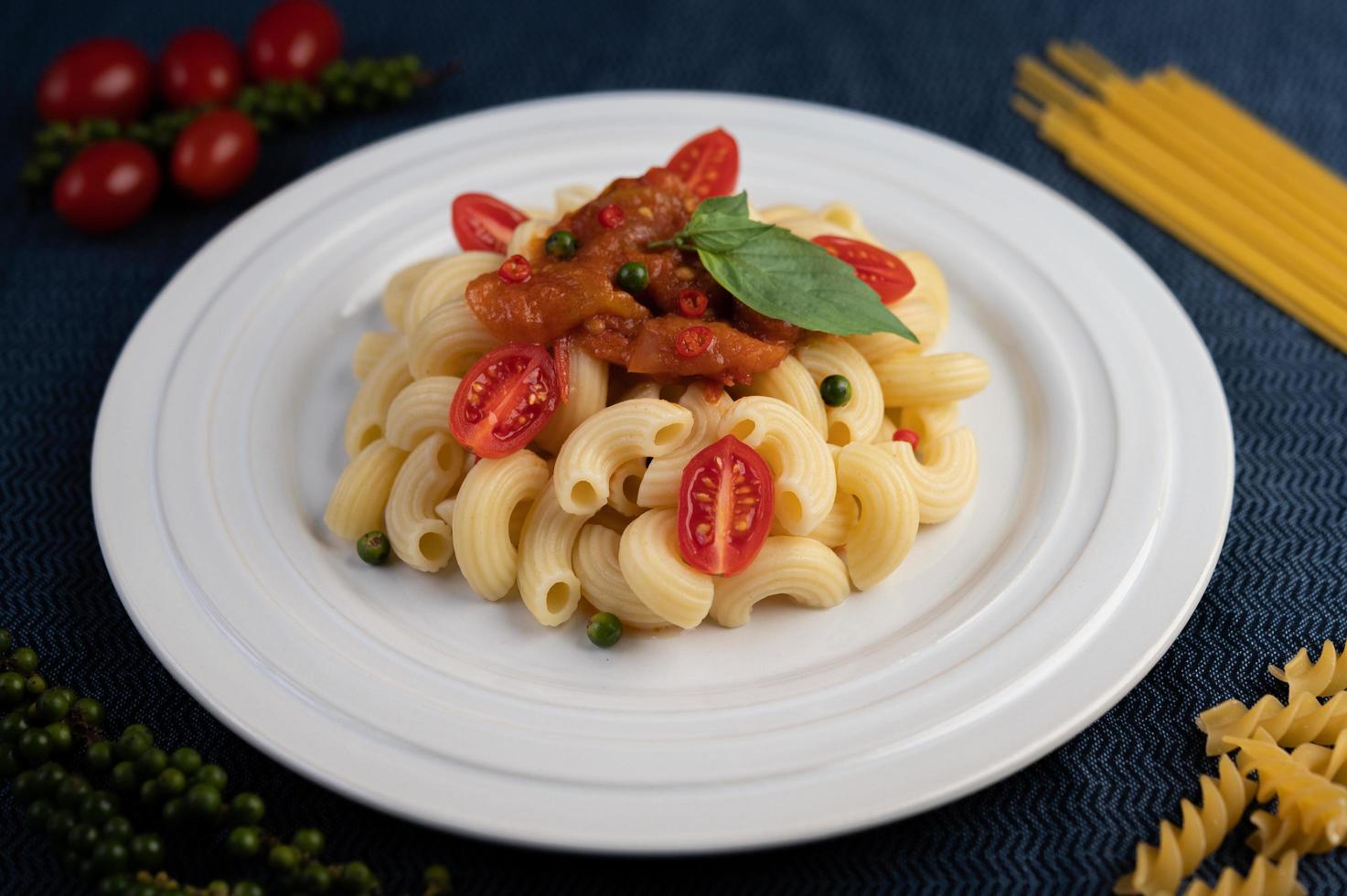 maccheroni saltati in padella con pomodoro, peperoncino, semi di peperone e basilico foto