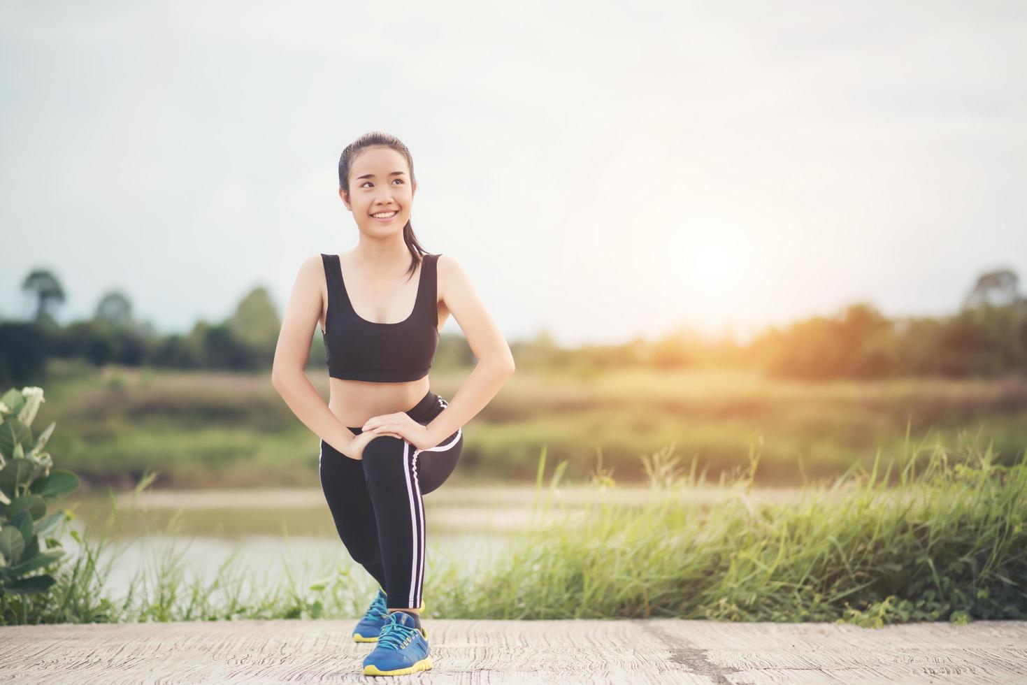 sana giovane donna in fase di riscaldamento all'aperto per la formazione foto