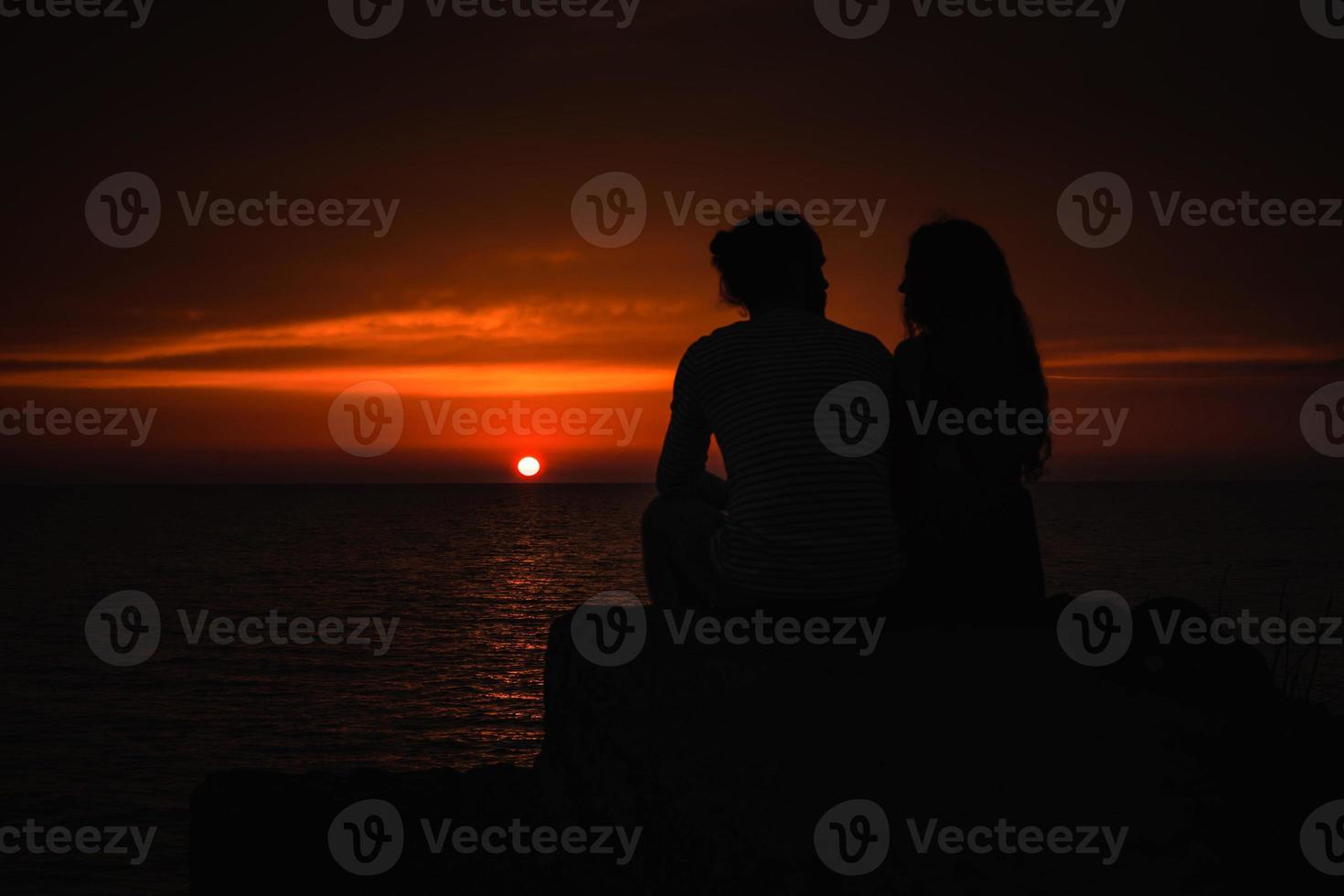 giovane coppia nel amore contro tramonto a mare foto