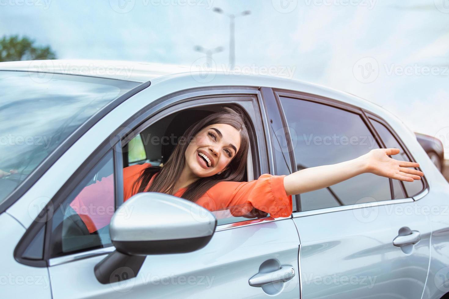 giovane donna seduta nel un' auto mano su di finestra. contento donna guida un' auto e sorridente. ritratto di contento femmina autista timone auto con sicurezza cintura. carino giovane signora contento guida macchina. foto