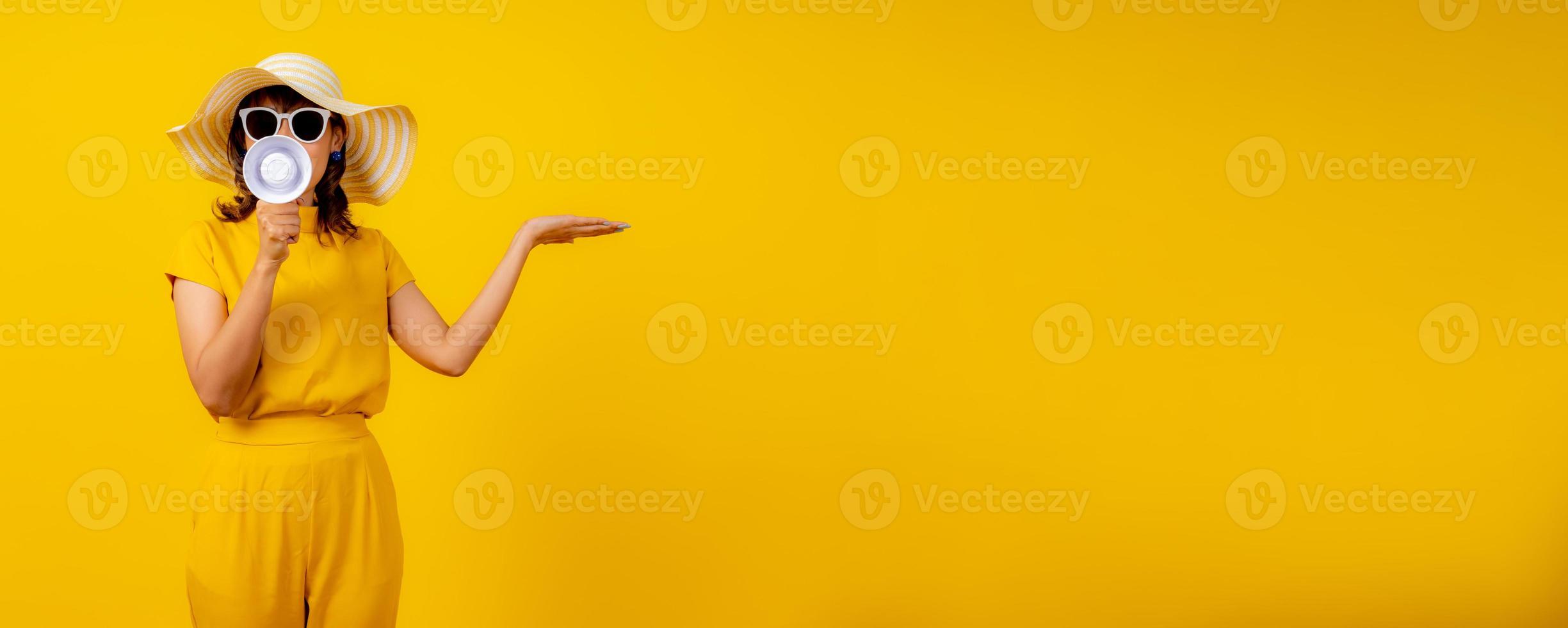 carino e divertente donna nel giallo casuale stoffa stile e indossare cappello Tenere bianca megafono per annuncio e mostrare mano per presente Prodotto foto