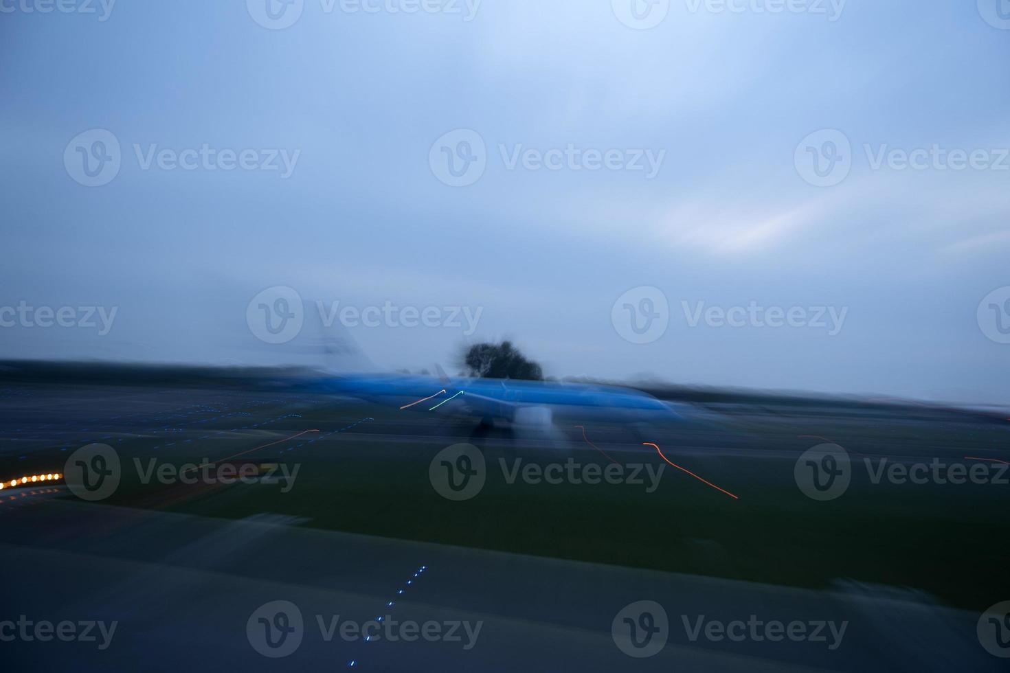 aeroporto luci nel movimento mentre aereo assunzione via a notte foto