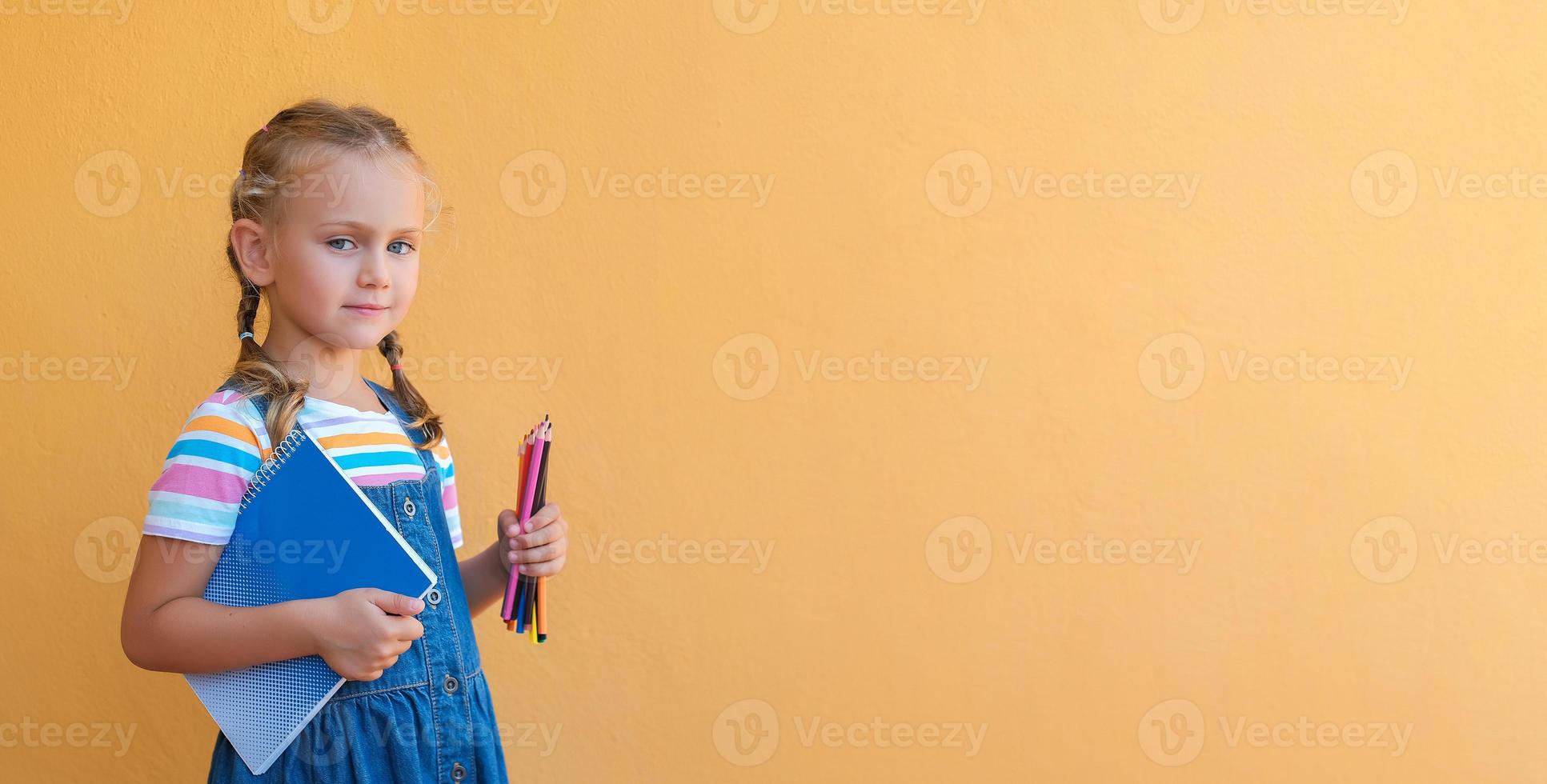 inteligente scolara bambino nel bicchieri nel scuola uniforme detiene colorato matite, taccuino, vuoto copia spazio isolato su giallo sfondo indietro per scuola foto