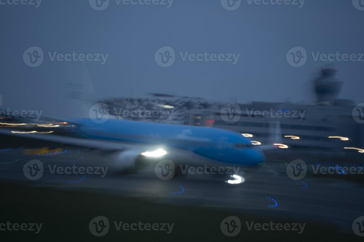 aeroporto luci nel movimento mentre aereo assunzione via a notte foto