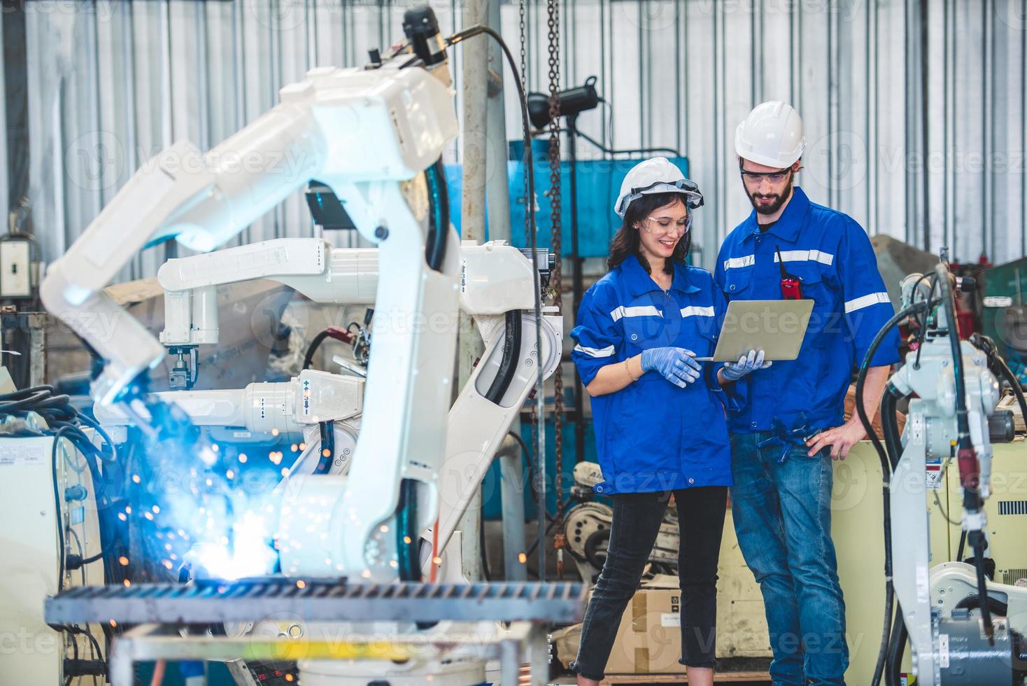 ingegneri squadra meccanico utilizzando computer controllore robotica braccio per saldatura acciaio nel acciaio fabbrica officina. industria robot programmazione Software per automatizzato produzione tecnologia foto